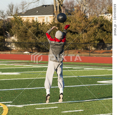 High school athlete throws medicine ball overhead 38440899