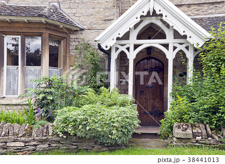 Dark brown wooden doors in old house with garden 38441013