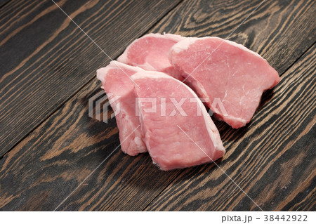Fresh raw pork steaks on a dark wooden background. 38442922