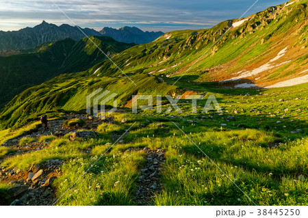 朝の三俣蓮華カールを行く登山者と槍・穂高の眺め 38445250