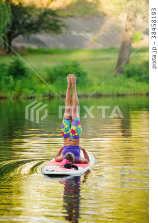 Young athletic woman doing fitness on a board  38458193