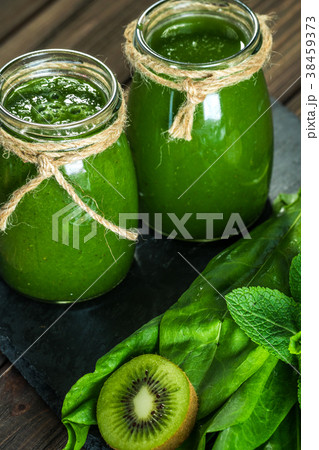 Blended green smoothie with ingredients on the Blended green smoothie with ingredients on the 38459373