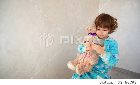 Girl with rabbit curiously clicks smartphone. Girl with rabbit curiously clicks smartphone. 38466798