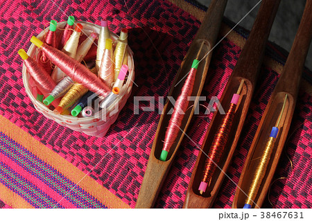 colorful bobbins in basket and wooden bobbin 38467631