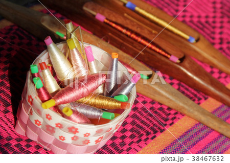 colorful bobbins in basket and wooden bobbin 38467632