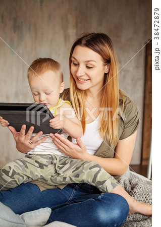 Young smiling mother with son using digital tablet Young smiling mother with son using digital tablet 38472879