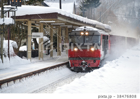 冬の北海道七飯町大沼公園駅を通過する貨物列車の風景を撮影 38476808