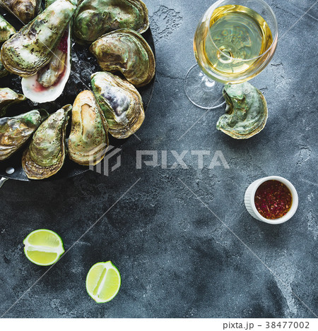 Fresh oysters platter with white wine and limes Fresh oysters platter with white wine and limes 38477002