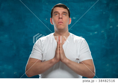 Young man posing on blue background Young man posing on blue background 38482516