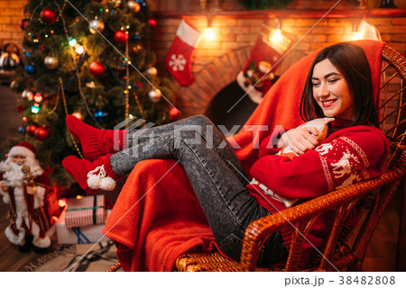 Young woman sitting on a chair, xmas celebration Young woman sitting on a chair, xmas celebration 38482808