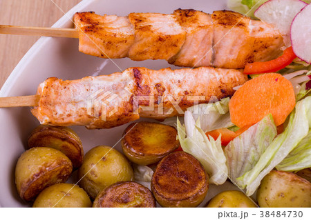 Fillet of a salmon on wooden brochettes with fried Fillet of a salmon on wooden brochettes with fried 38484730