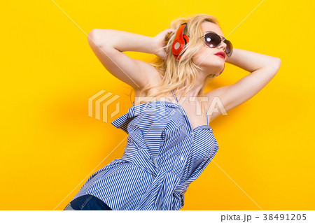 Girl in blouse with headphones and sunglasses 38491205