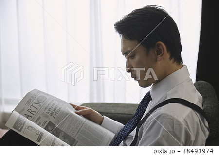 英字新聞を読むお洒落なビジネスマン 38491974