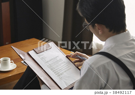 契約書にサインをするお洒落なビジネスマン 38492117