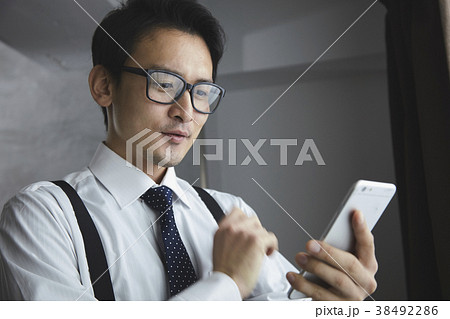 スマホを使うお洒落なビジネスマン 38492286