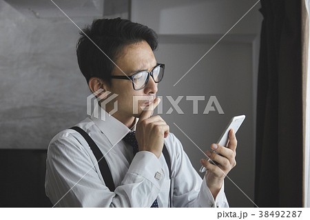 スマホを使うお洒落なビジネスマン スマホを使うお洒落なビジネスマン 38492287