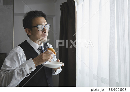 リビングでパンを食べるお洒落なビジネスマン リビングでパンを食べるお洒落なビジネスマン 38492803