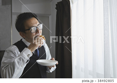リビングでパンを食べるお洒落なビジネスマン 38492805