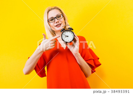 Blonde woman holding alarm clock 38493391