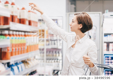 スーパーマーケットで買い物をする若い女性 スーパーマーケットで買い物をする若い女性 38496596