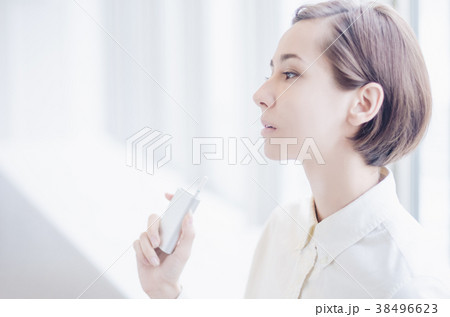 加熱式タバコを吸うショートヘアーの女性 加熱式タバコを吸うショートヘアーの女性 38496623