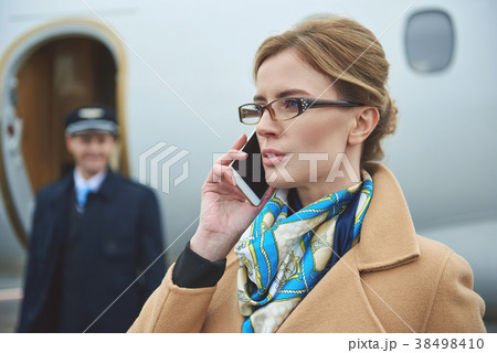 Serene girl talking by phone near aircraft 38498410