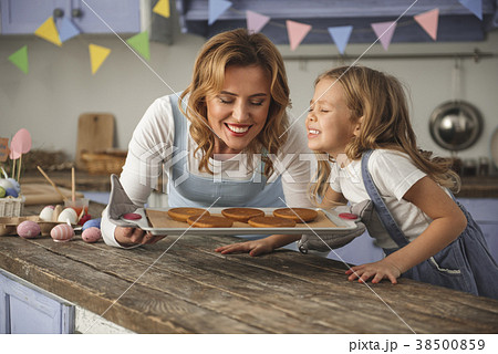 Cheerful mother and kid sniffing pastry on the Cheerful mother and kid sniffing pastry on the 38500859