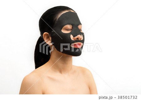 Young woman doing facial black mask sheet Young woman doing facial black mask sheet 38501732