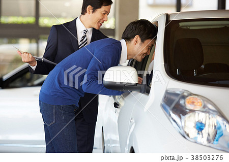 自動車ディーラー　購入を検討する男性 38503276