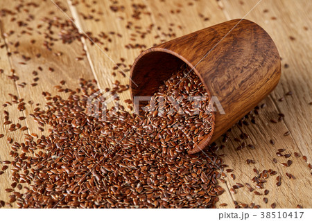 An overturned wooden bowl with linseeds on a 38510417