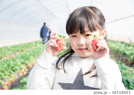 笑顔でいちごを持つ女の子 38518001