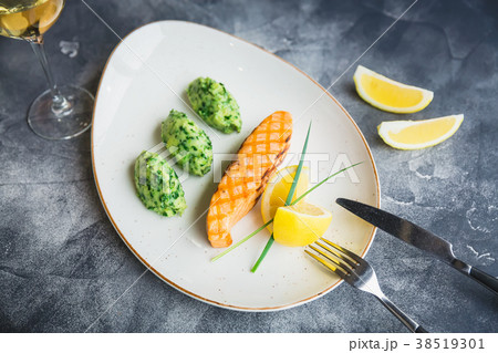 Dish with grilled salmon with lemon slices 38519301