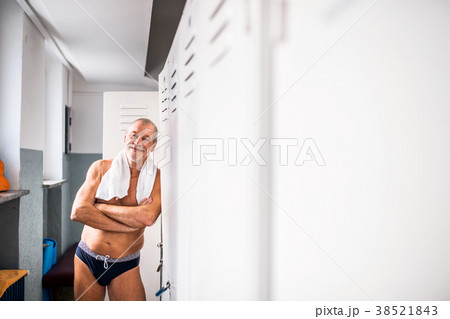 Senior man standing by the lockers in an indoor Senior man standing by the lockers in an indoor 38521843