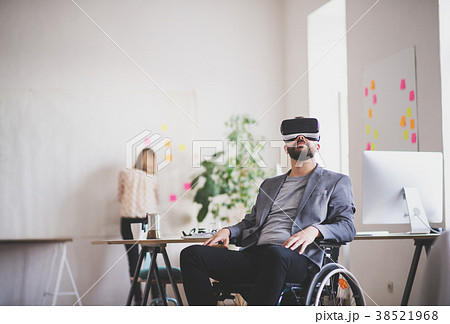 Two business people with wheelchair and VR goggles Two business people with wheelchair and VR goggles 38521968