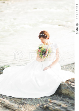 Gorgeous beautiful bride smiles while posing by Gorgeous beautiful bride smiles while posing by 38523863