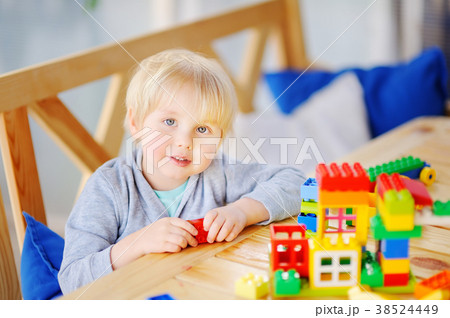 Little boy playing with colorful plastic blocks at kindergarten or at home 38524449