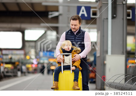 Cute little boy and his father waiting express train on railway station platform Cute little boy and his father waiting express train on railway station platform 38524511
