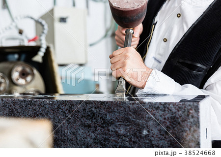 Stone mason working on tombstone in workshop Stone mason working on tombstone in workshop 38524668