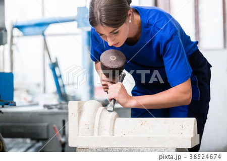 woman Stonemason carving pillar out of stone in 38524674