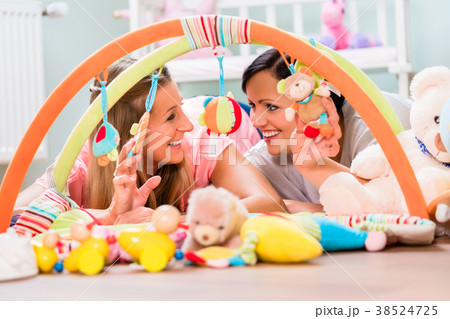 Women furnishing baby room preparing play bar for Women furnishing baby room preparing play bar for 38524725