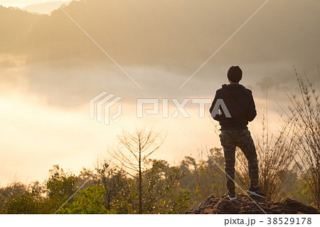 Traveler standing on mountain peak  38529178