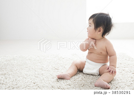 裸で泣く7ヶ月の赤ちゃんの写真素材
