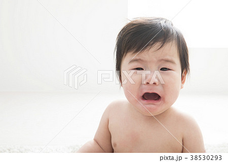 裸で泣く7ヶ月の赤ちゃんの写真素材