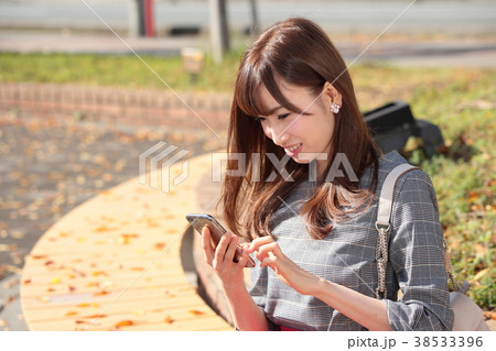 携帯をいじる若い女性の写真素材