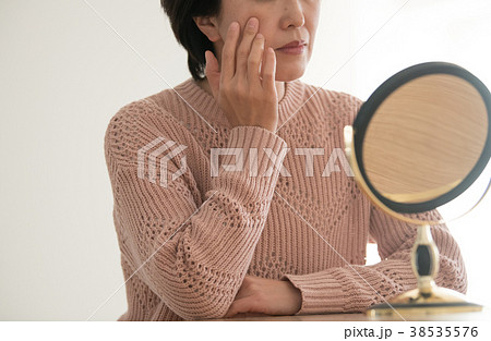 肌を気にして鏡を見るミドル女性 38535576