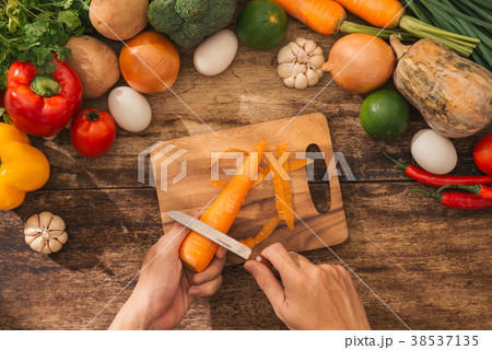 Cutting carrot. Male hands cooking vegetables  Cutting carrot. Male hands cooking vegetables  38537135