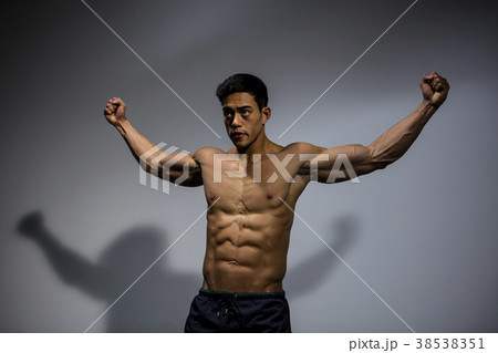 Fitness Model Displaying Biceps and Pectorals With Stretched Out