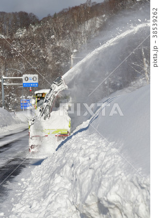 大雪の降った朝の国道で除雪をする北海道開発局の除雪車の風景を撮影の写真素材