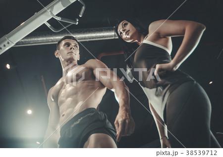 Model young man and woman working out in gym Model young man and woman working out in gym 38539712