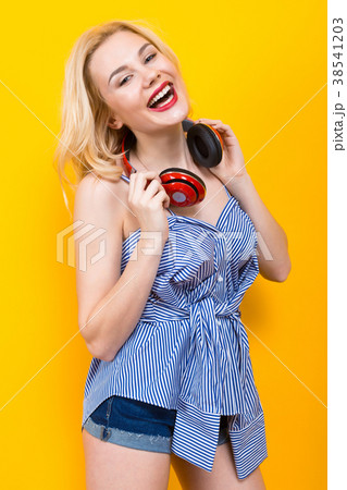 Blonde girl in blue striped blouse with headphones Blonde girl in blue striped blouse with headphones 38541203